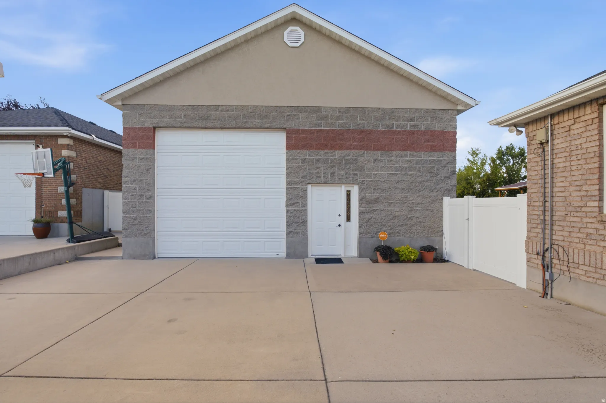 Two-story auxiliary structure featuring a segmented garage door, a side entry door with a sidelight, and a gable roofline