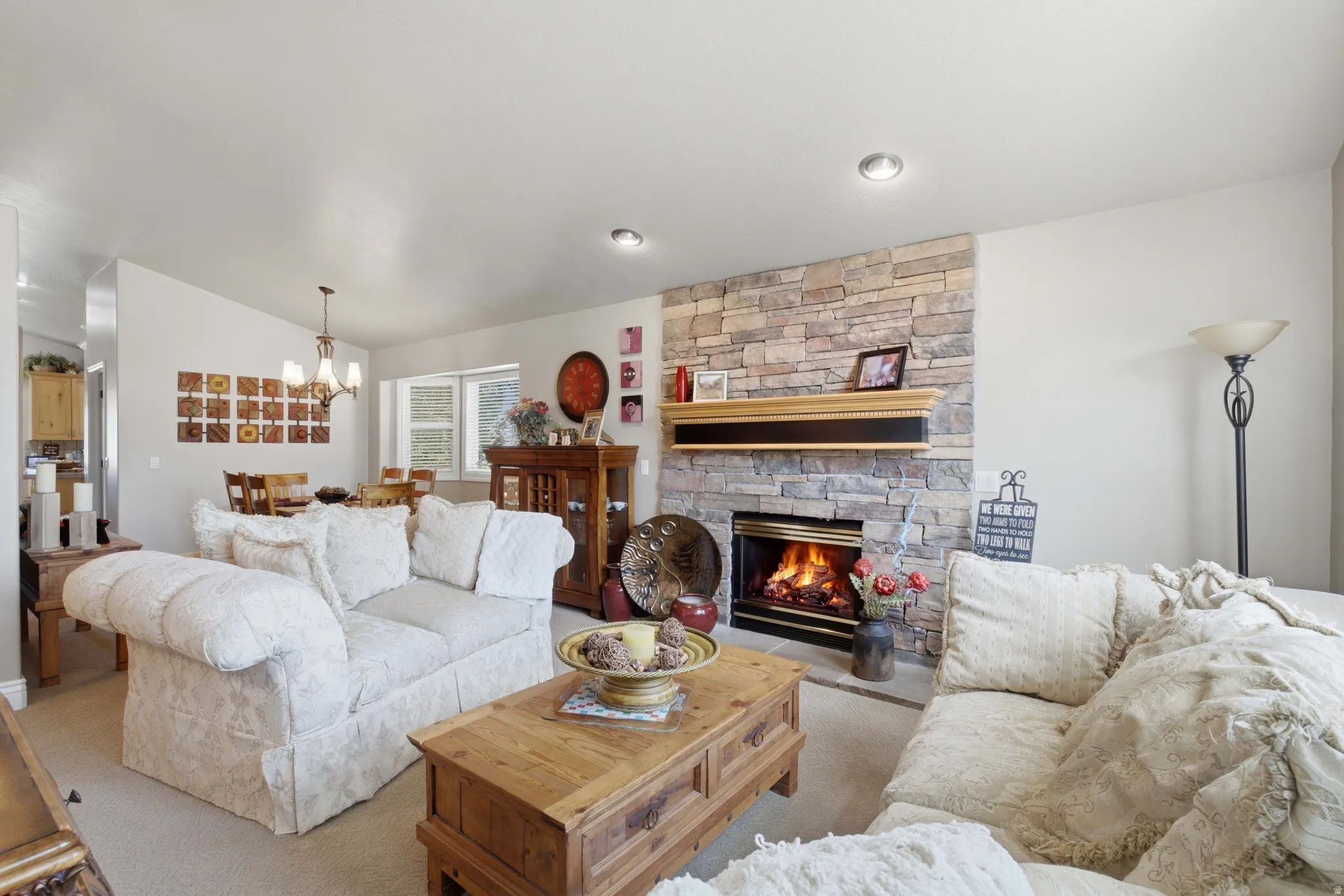 Living area featuring a stone accent wall with a built-in fireplace, a wood mantle, and recessed lighting