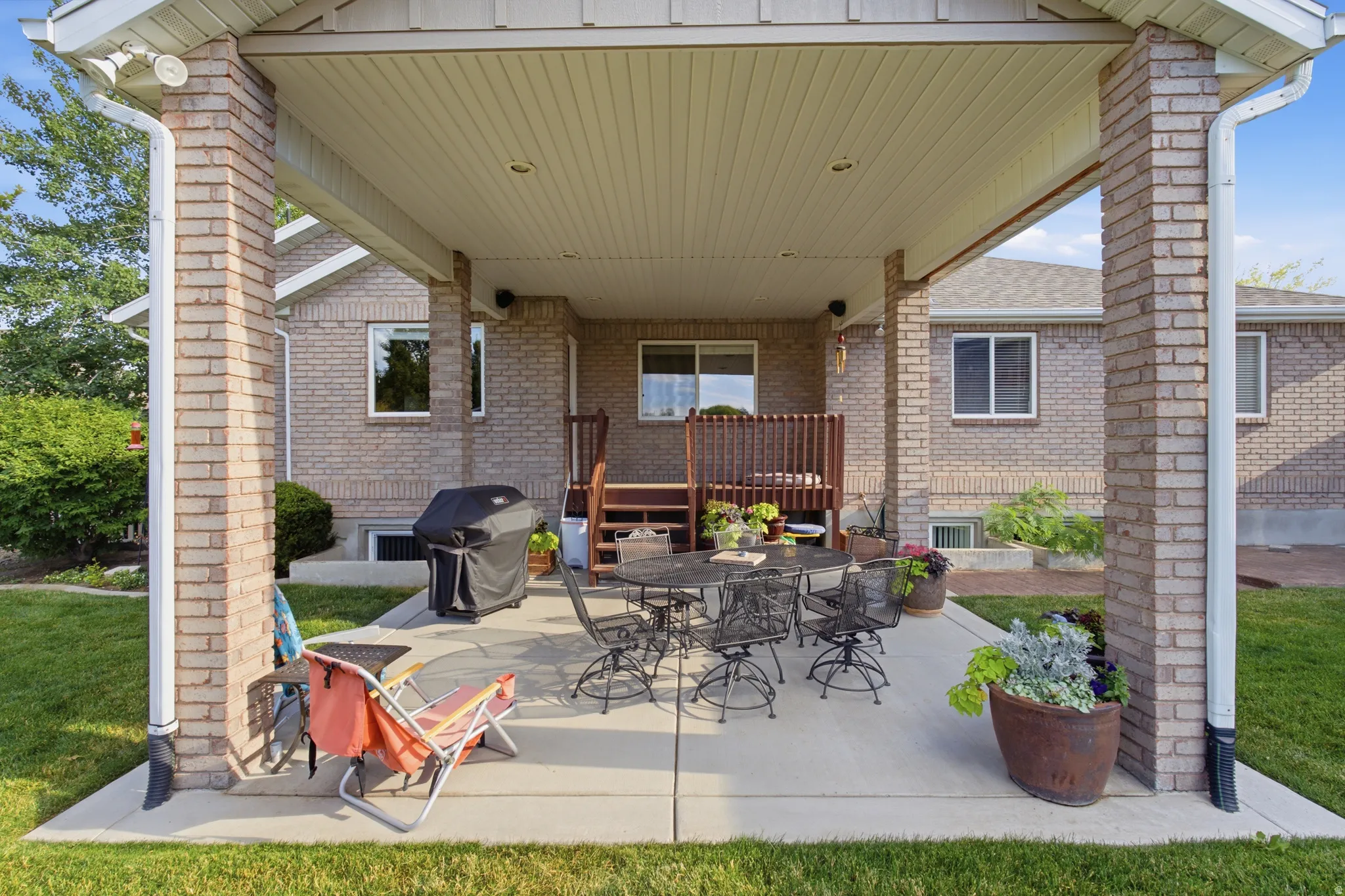 Covered patio featuring brick columns and a concrete surface