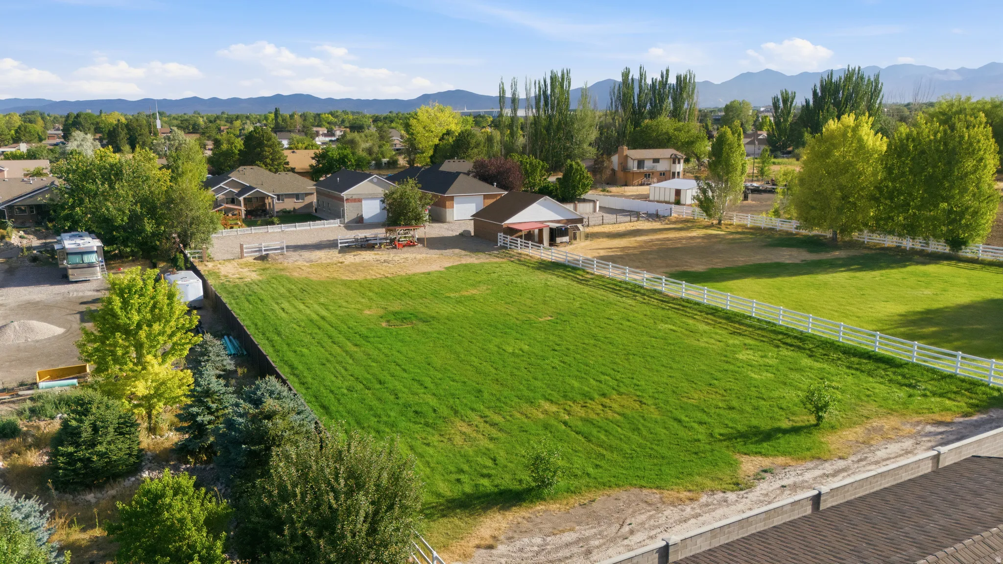Expansive green lawn area with white perimeter fencing
