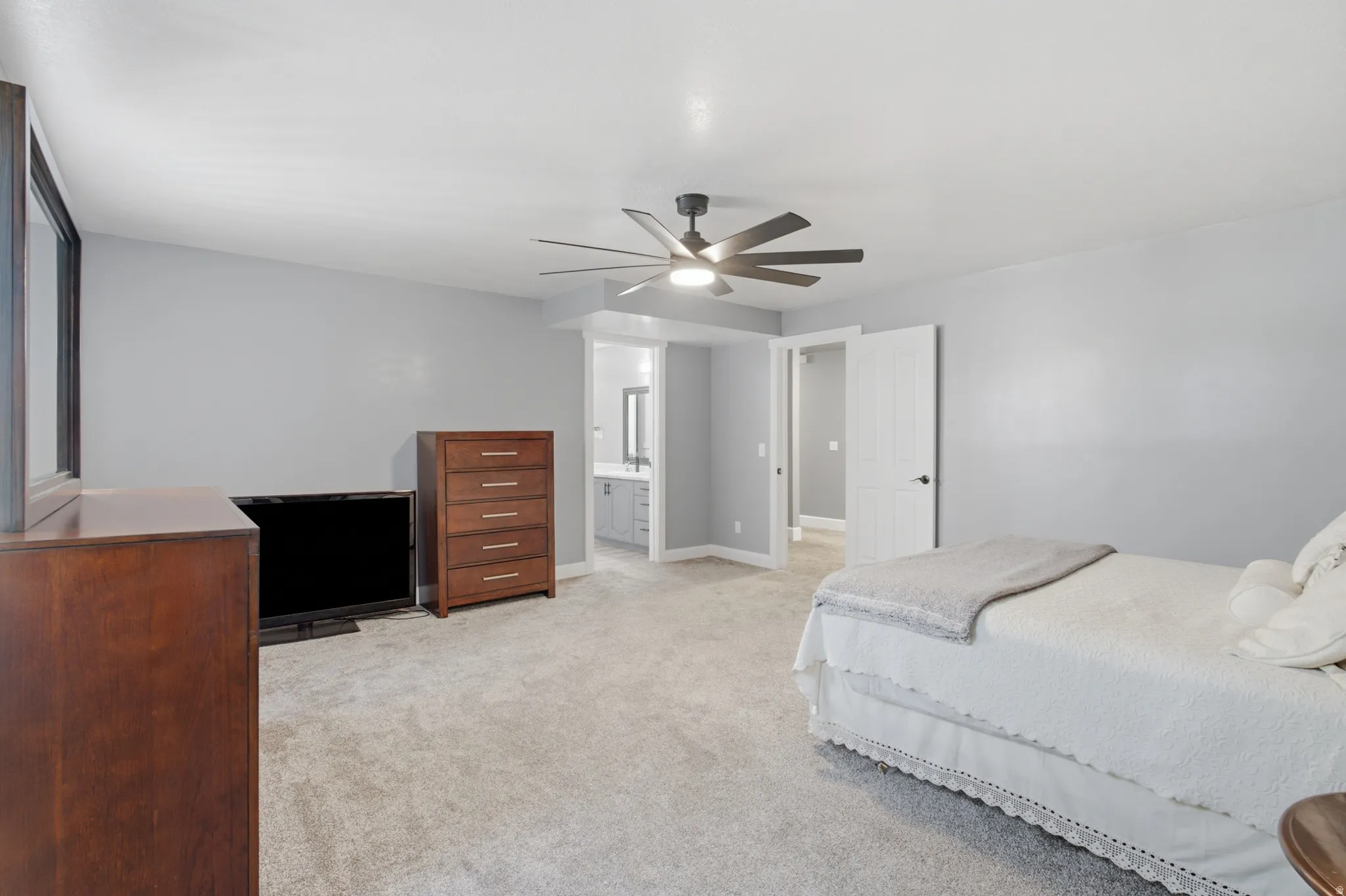 Spacious room with light gray wall finishes and neutral carpet flooring