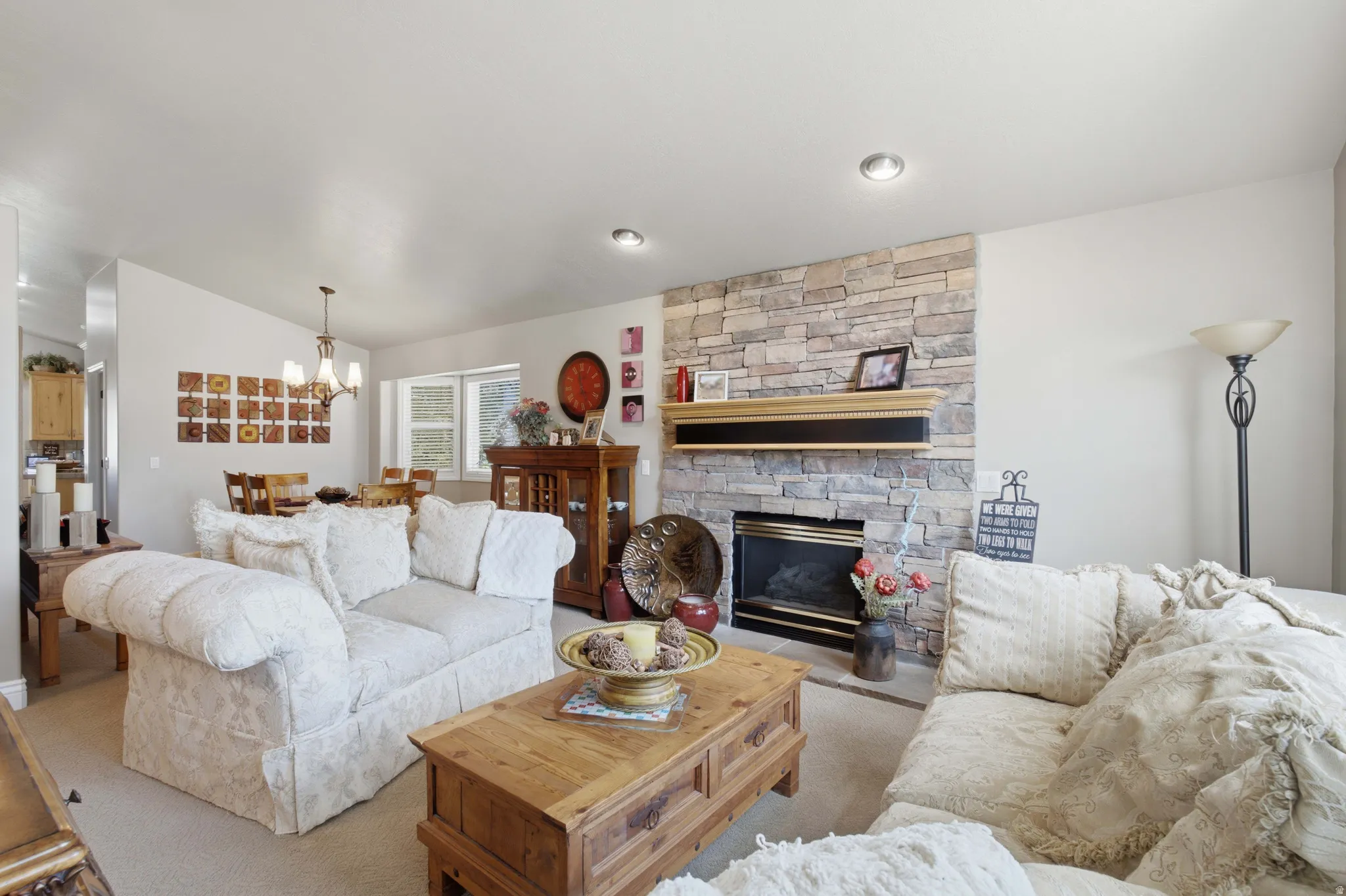 Living room featuring a stone-clad fireplace with a black framed insert and a wood mantel