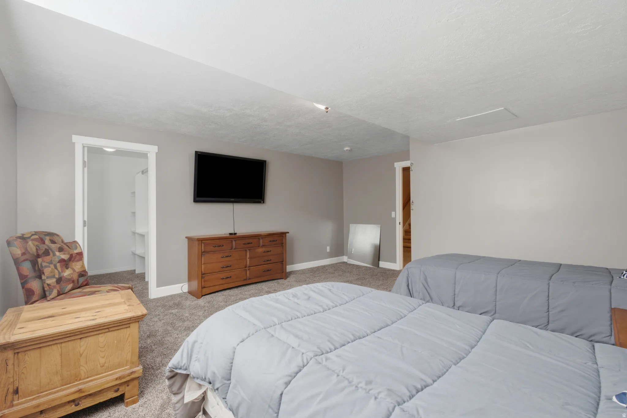 Bedroom featuring neutral gray wall paint and textured carpet flooring