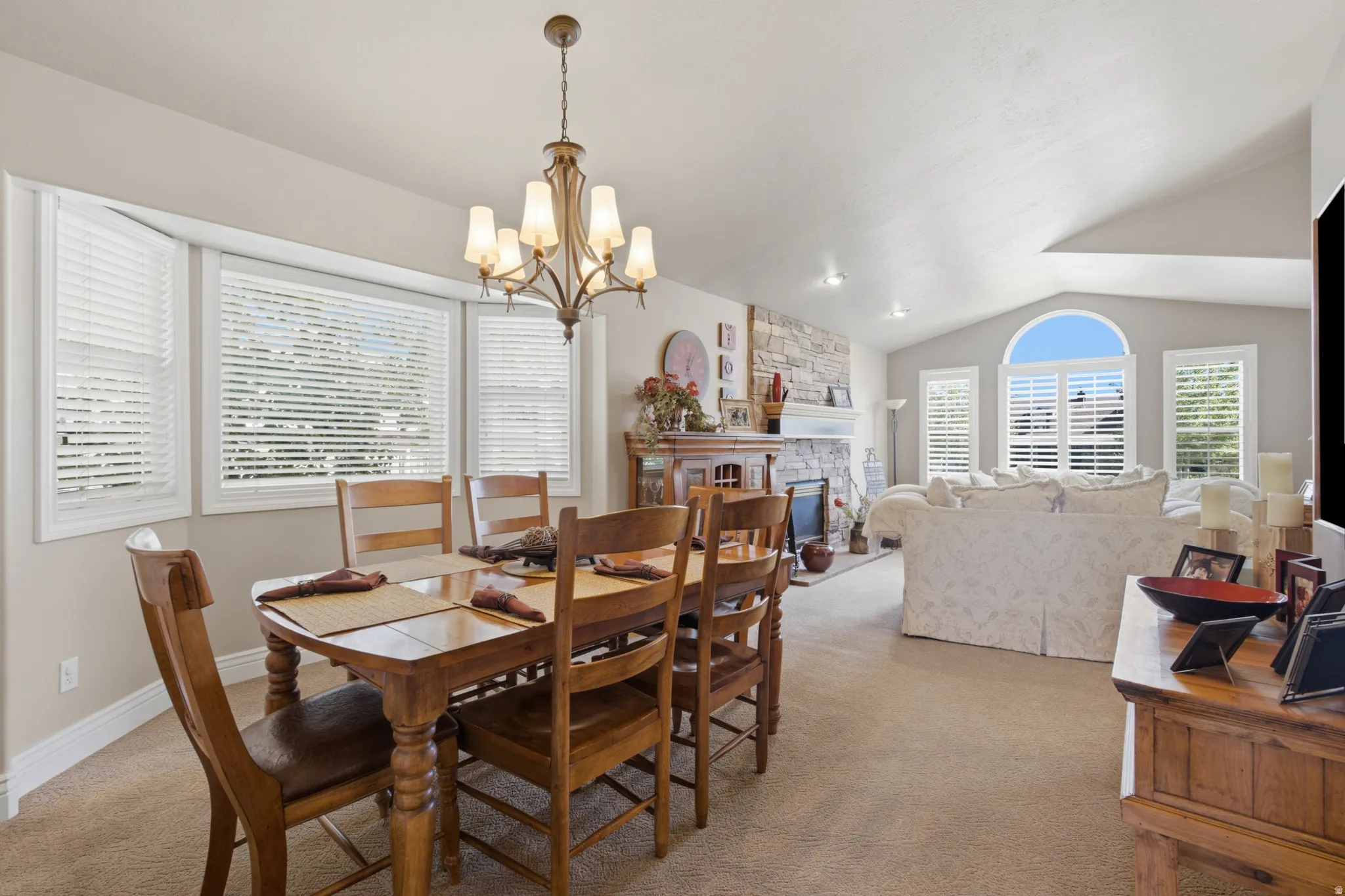 Dining area featuring a classic chandelier and bay windows with blinds