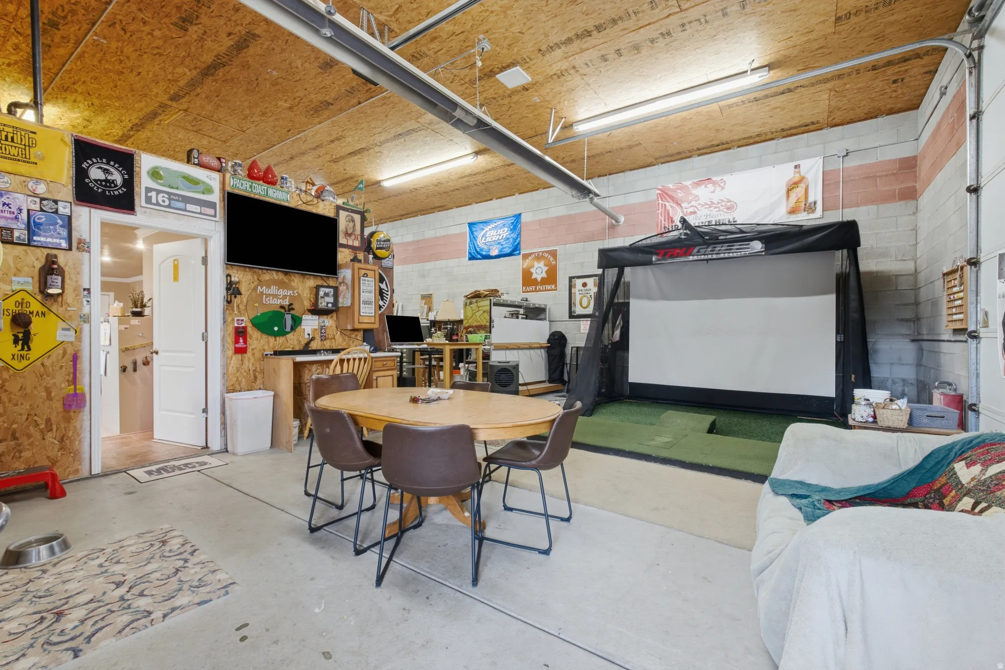 Spacious multi-functional garage space featuring exposed wood paneling and concrete block walls