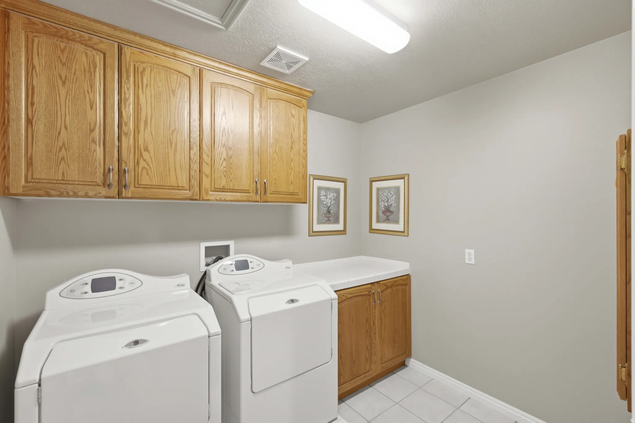 Utility room featuring wood cabinetry and a white countertop
