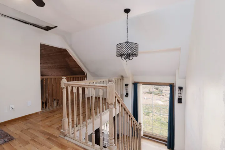 Wood-finish flooring throughout, featuring a natural wood staircase with balusters