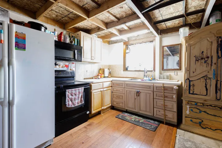 Kitchen featuring wood-finish flooring and exposed beam ceiling
