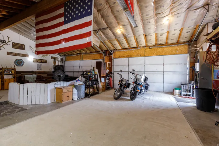 Spacious garage featuring concrete flooring and two overhead garage doors
