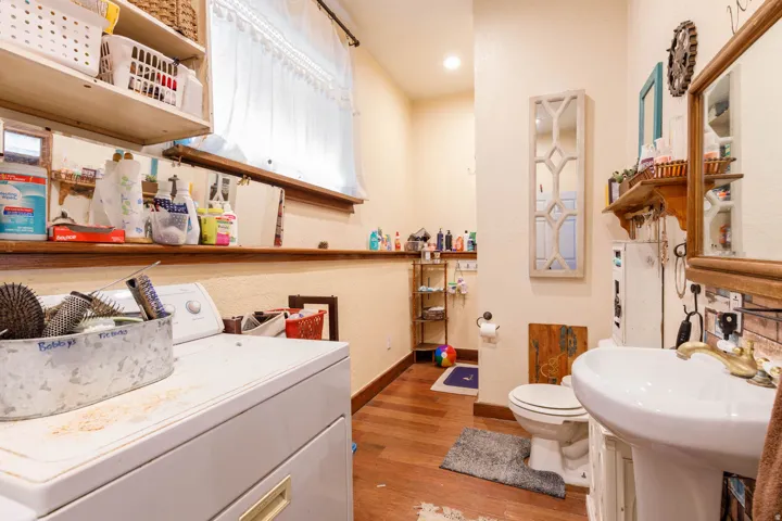 Laundry area with wood-finish flooring