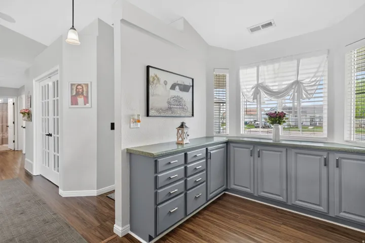 Built-in cabinetry with gray finishes and a light-toned countertop, complemented by wood-finish flooring