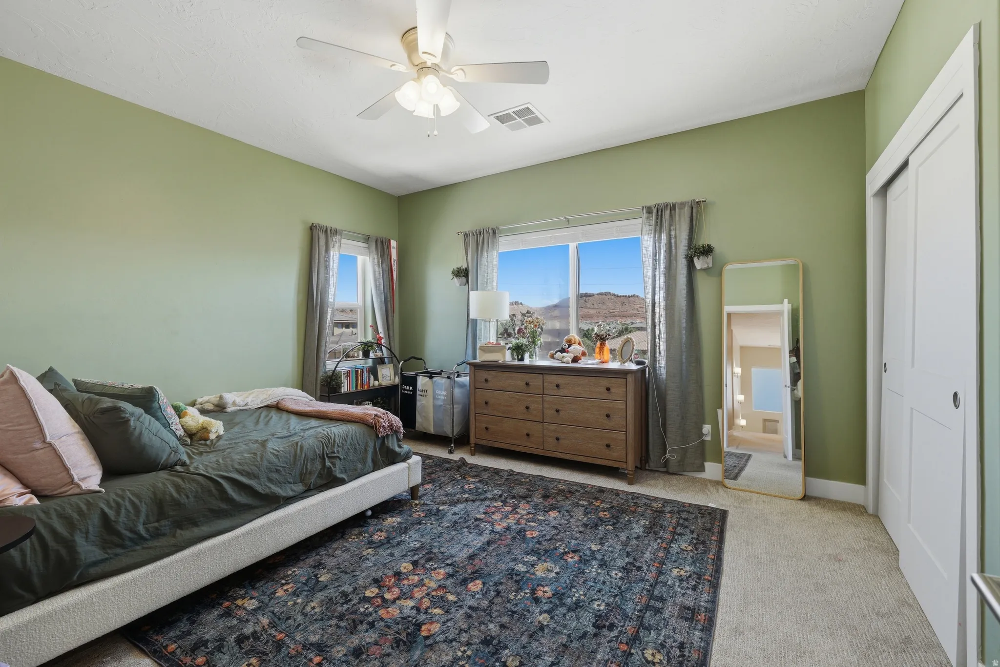 Spacious room featuring two large windows, offering abundant natural light and scenic mountain backdrops