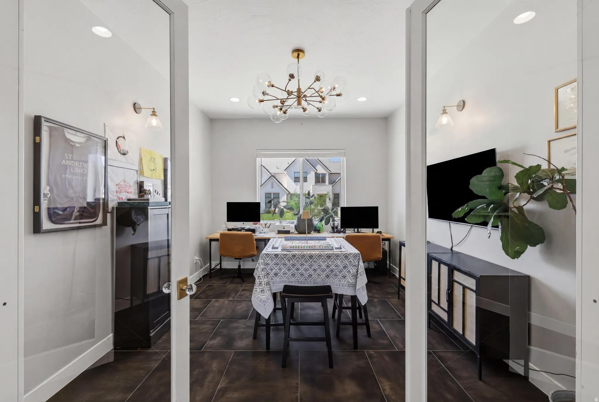 French doors with glass panels open to a versatile room featuring wood-finish flooring, a contemporary chandelier, and recessed lighting