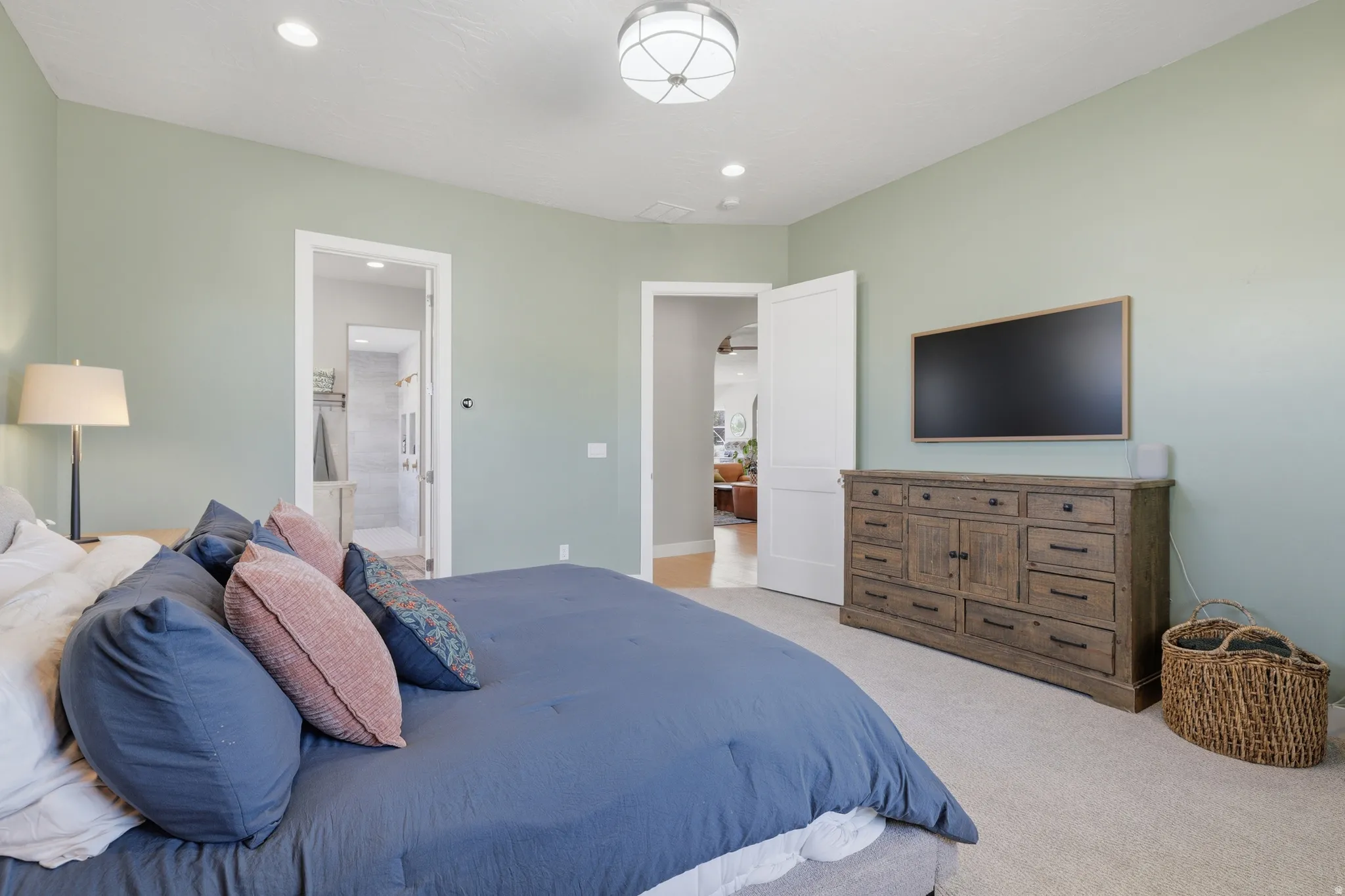 Bedroom featuring light green walls and light-toned carpet flooring