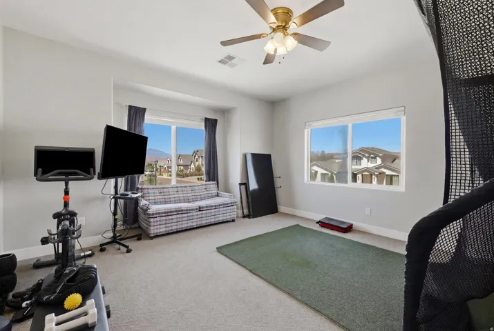 Spacious room featuring multiple windows, neutral wall tones, and carpet flooring