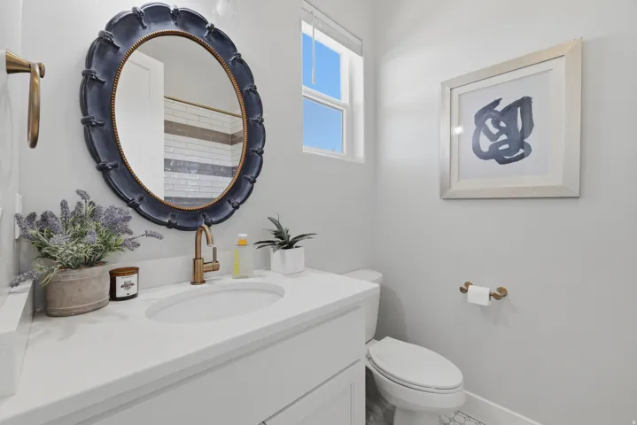 Bathroom vanity featuring a white countertop, an undermount sink, and a gold-finish faucet