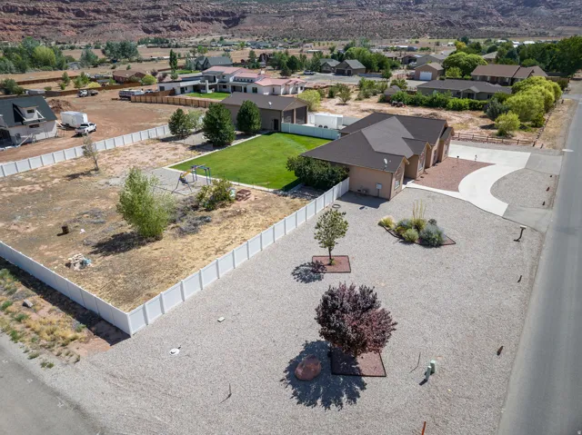 Single-story residence featuring an attached garage, a paved driveway, and a gravel front yard with mature landscaping