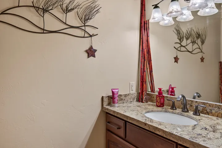 Vanity featuring a stone countertop, an undermount sink, and a dark bronze widespread faucet