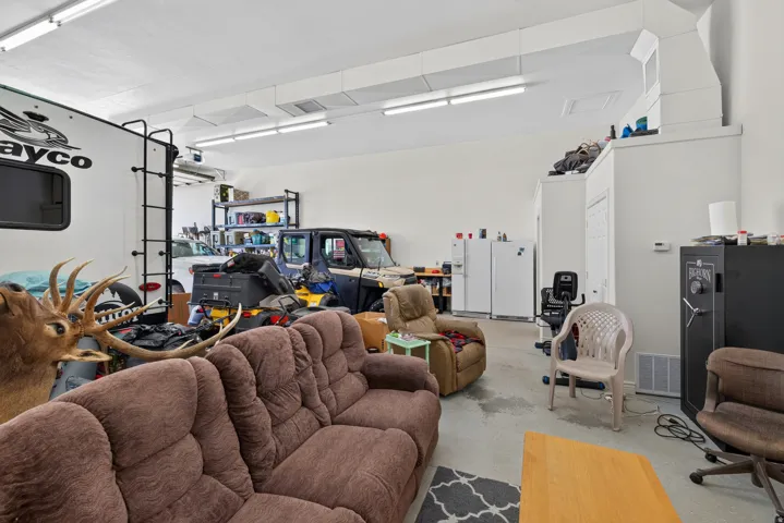 Spacious interior featuring a high ceiling, multiple fluorescent light fixtures, and a concrete floor