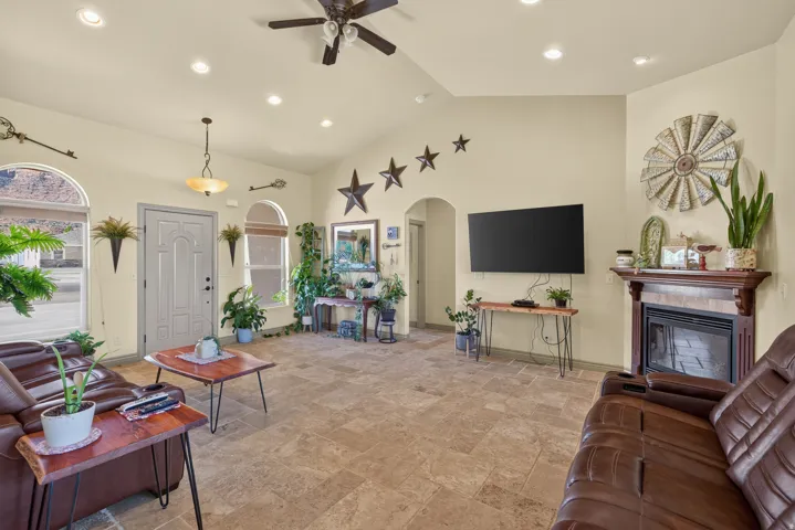 Spacious living area featuring vaulted ceilings, recessed lighting, and tile flooring