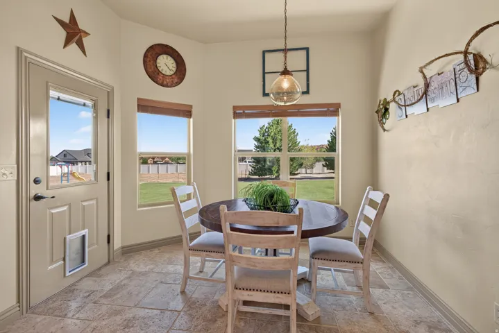 Dining area featuring a circular wooden table, tile flooring, and multiple windows