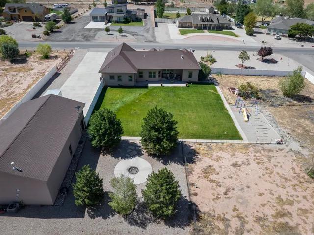 Expansive property featuring a detached outbuilding with a private driveway, a manicured lawn, and a dedicated play area