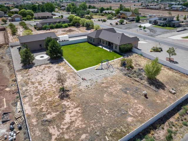 Extensive property featuring a single-story residence, detached outbuilding, and a large, fenced backyard with manicured lawn