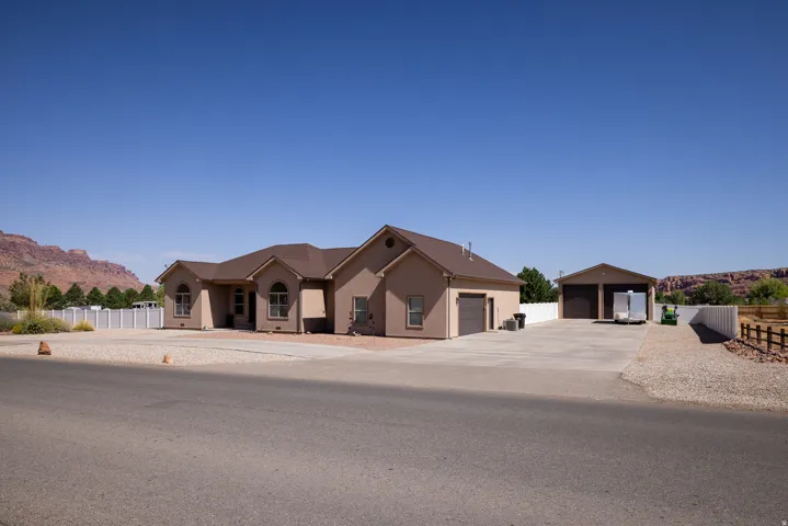 Single-story stucco residence featuring a two-car garage and an additional detached two-car garage