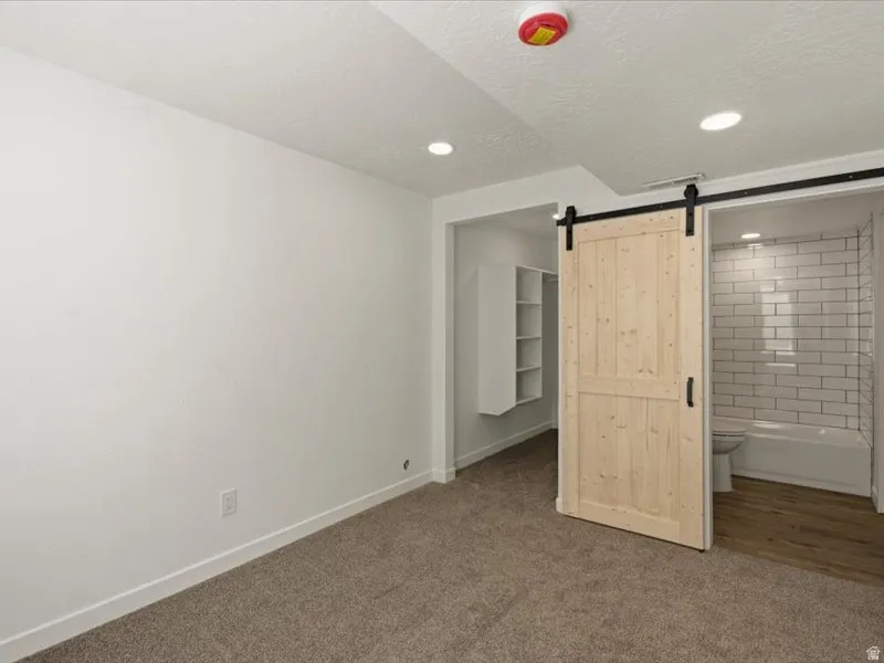 Bedroom space featuring warm-toned carpet flooring and recessed lighting