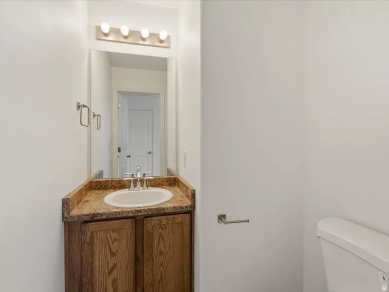 Bathroom vanity featuring a wood-finish cabinet, a drop-in sink, and a speckled countertop