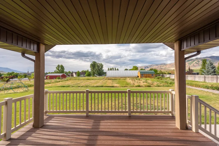 Covered porch featuring wood-finish decking and white baluster railing