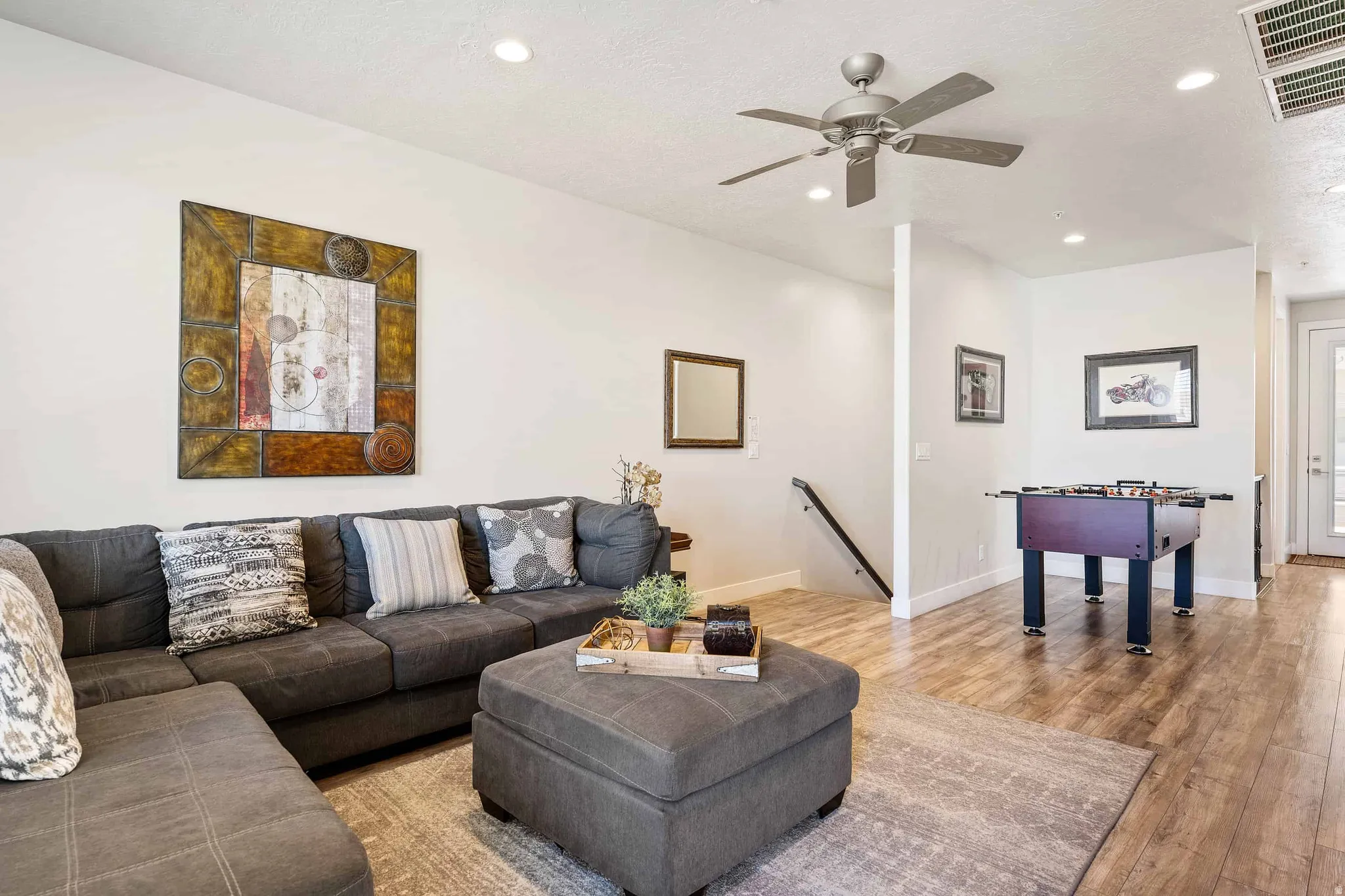Spacious room featuring wood-finish flooring, recessed lighting, and a ceiling fan