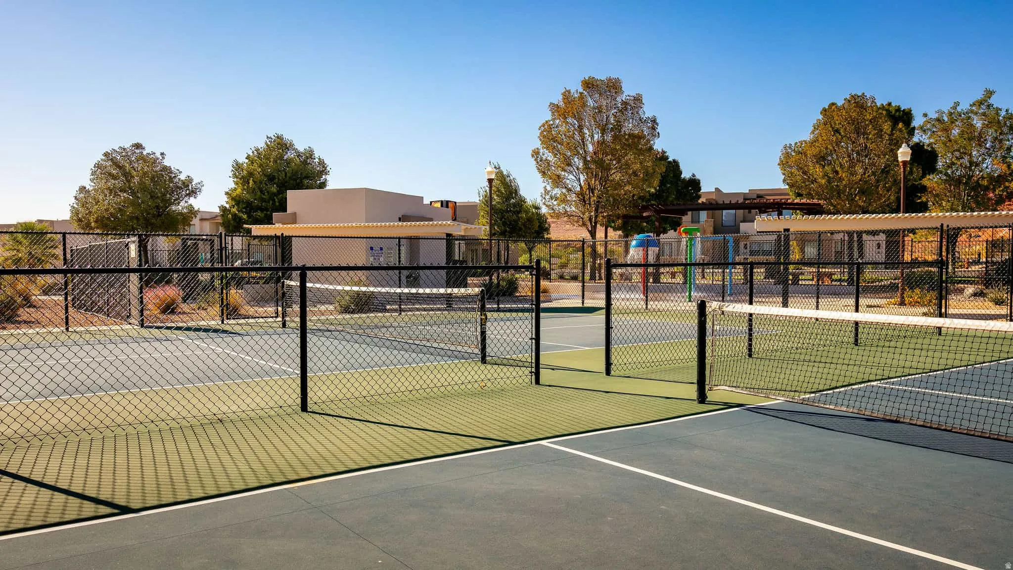 Hard surface courts with black chain link fencing