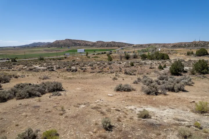 Expansive undeveloped land featuring natural vegetation and distant mountain ranges