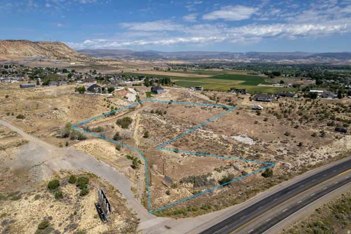 Expansive vacant land parcels outlined, featuring a varied terrain with natural vegetation