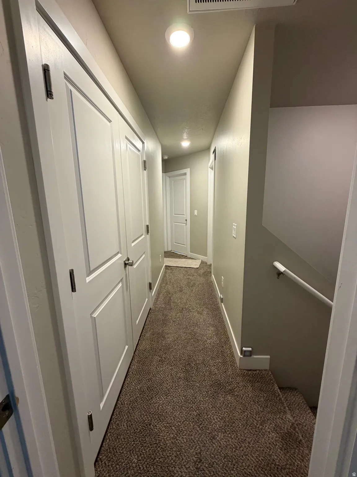 Hallway with recessed lighting, neutral wall paint, white trim, and brown carpet flooring