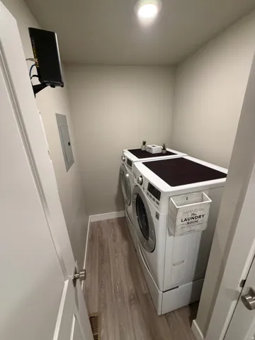 Dedicated laundry area featuring wood-finish flooring and a ceiling-mounted light fixture