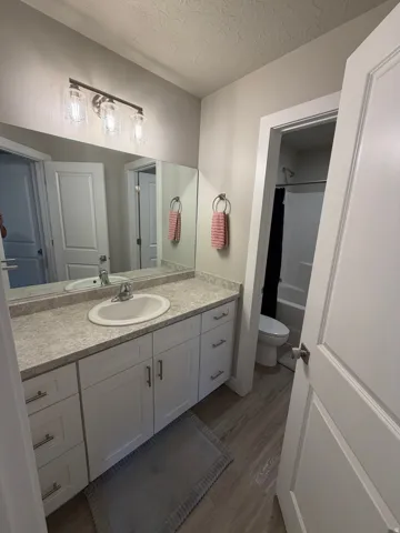 Bathroom featuring a white vanity with a light-toned countertop, a single undermount sink, and brushed nickel hardware