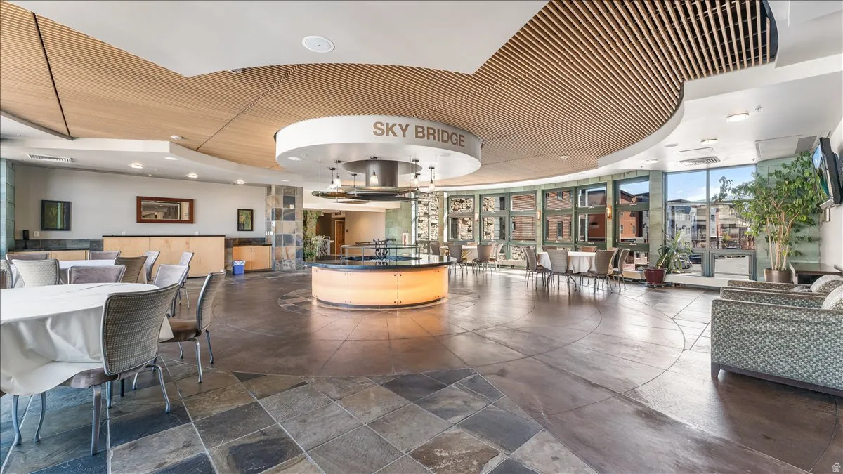 Spacious common area featuring slate tile flooring, a slatted wood-finish ceiling, and large windows