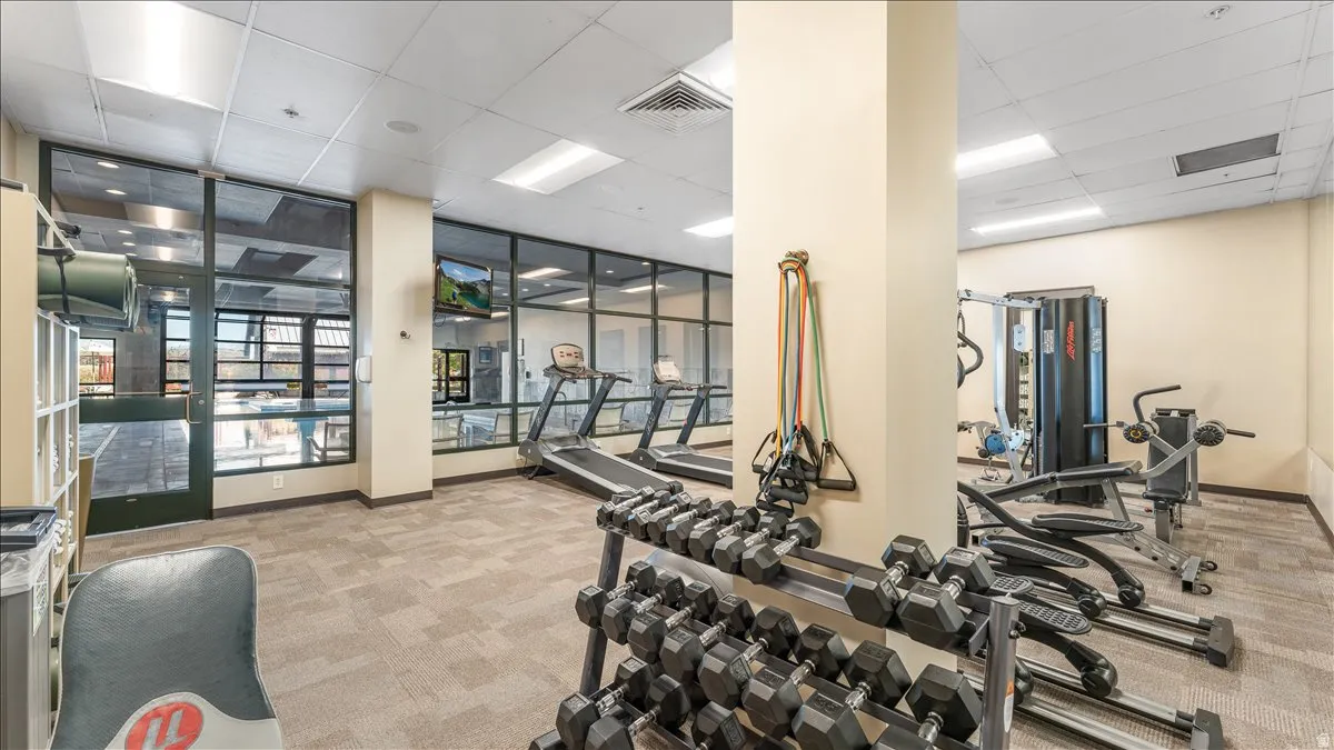 Fitness center featuring glass wall partitions and durable carpet tile flooring