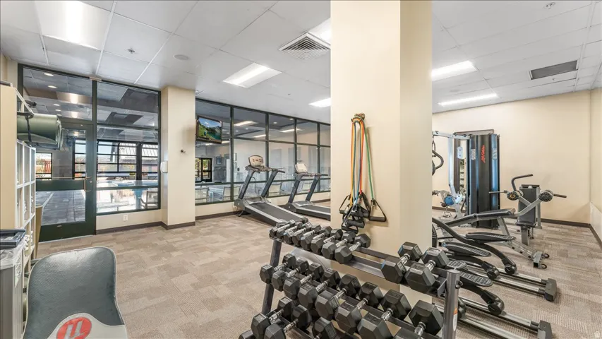 Fitness center featuring glass wall partitions and durable carpet tile flooring