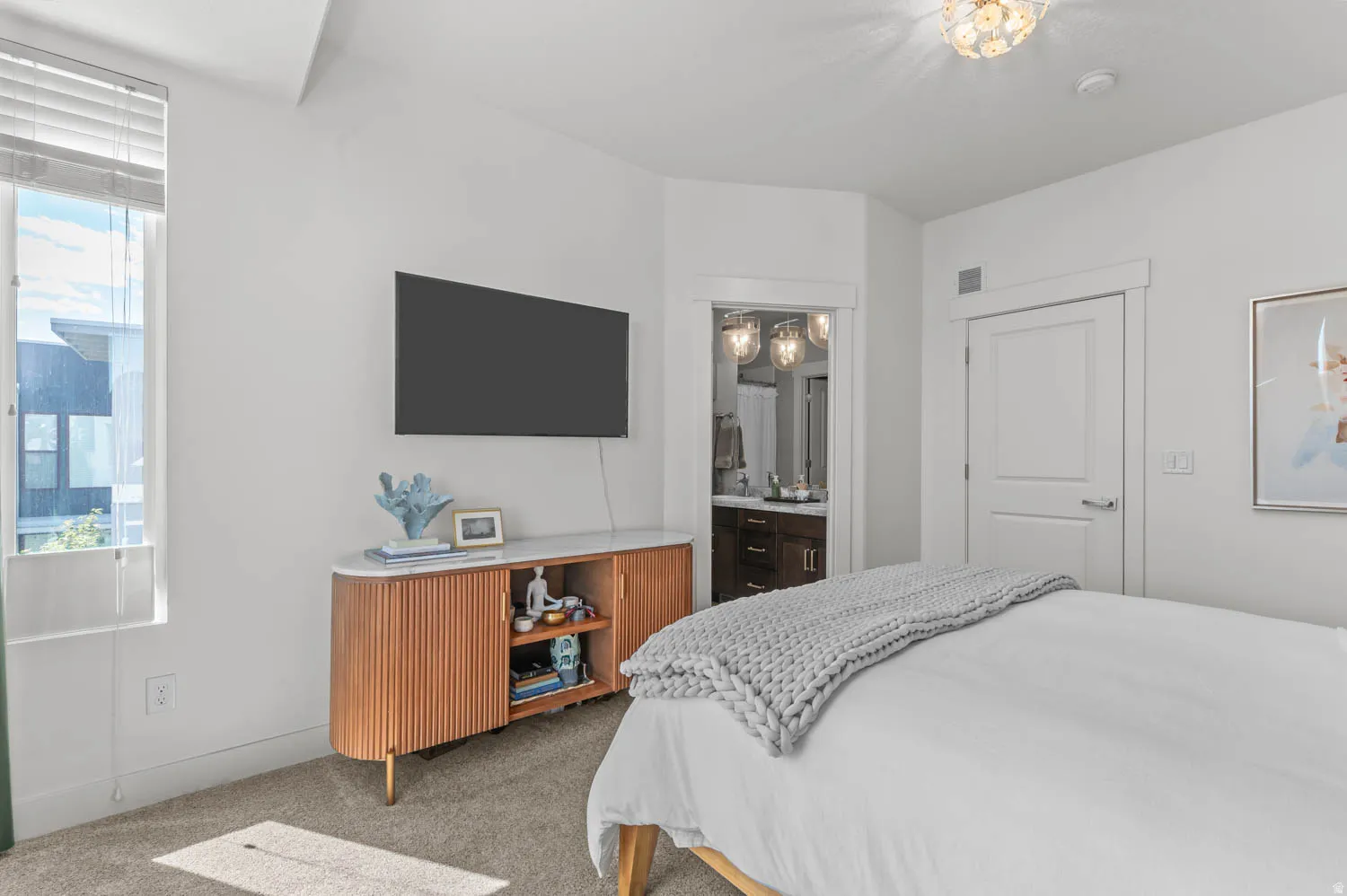 White bedroom featuring a built-in media console with a light-toned wood finish and a light-colored countertop