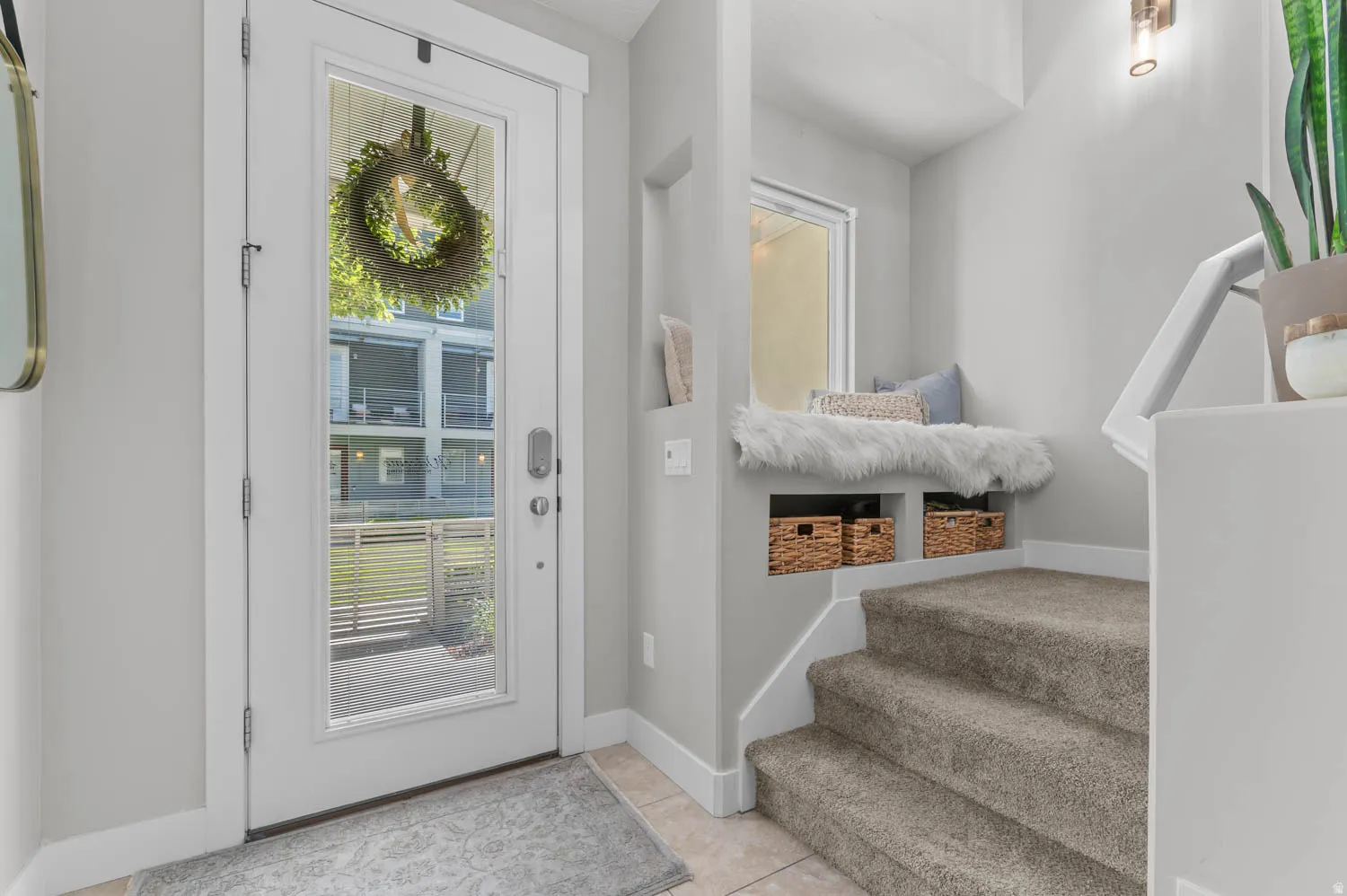 Entryway featuring a full-light panel door, tiled flooring, and a built-in window bench with integrated storage nooks