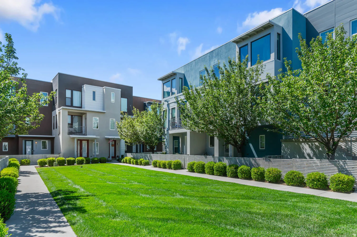 Contemporary multi-story facades featuring varied sidings and large windows