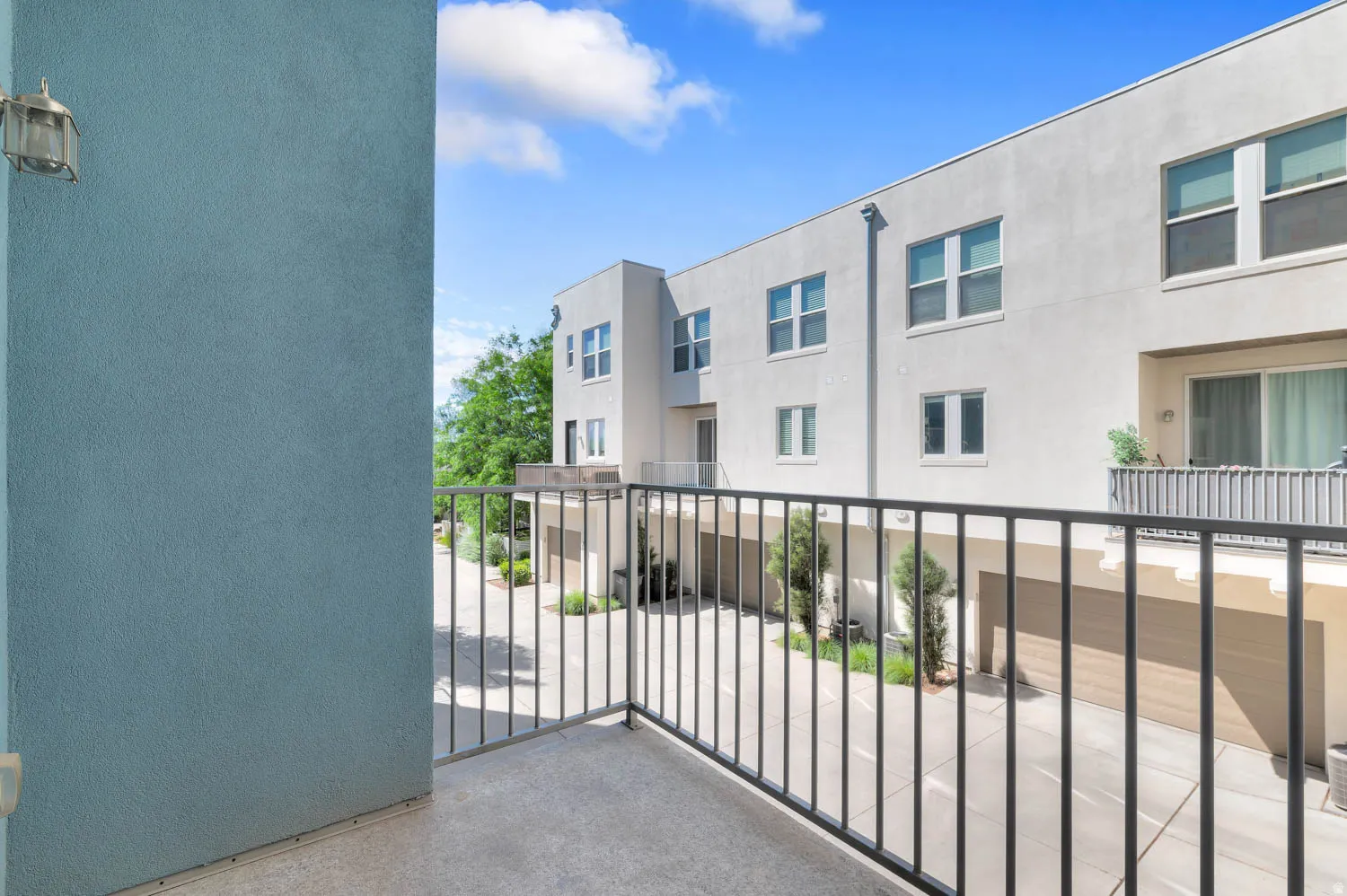 Private balcony featuring a concrete floor and black metal railing