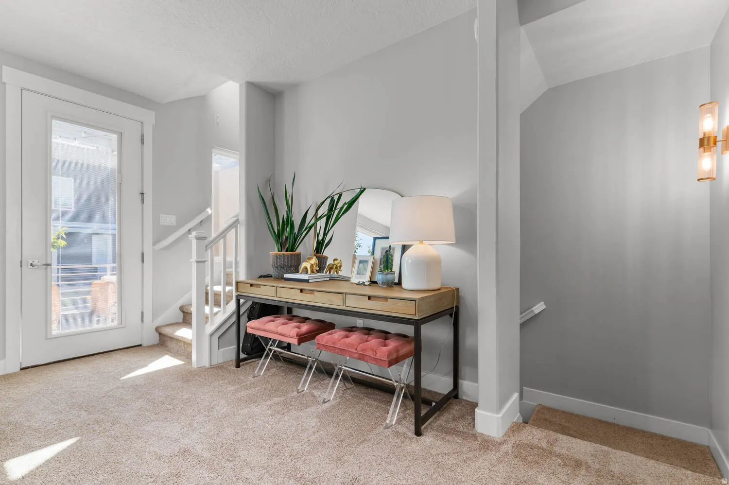Entryway featuring a full-light glass door, neutral-toned carpet flooring, and a two-story staircase with white railings