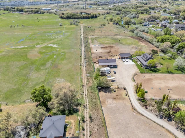 Expansive property featuring multiple structures, a large equestrian arena, and extensive open fields