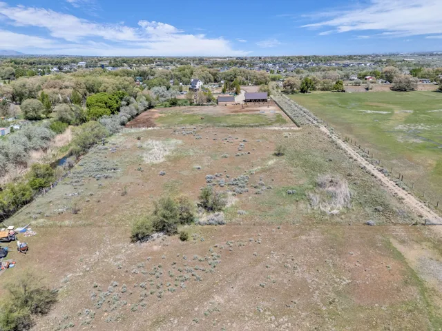 Expansive open land featuring diverse vegetation and a natural water channel