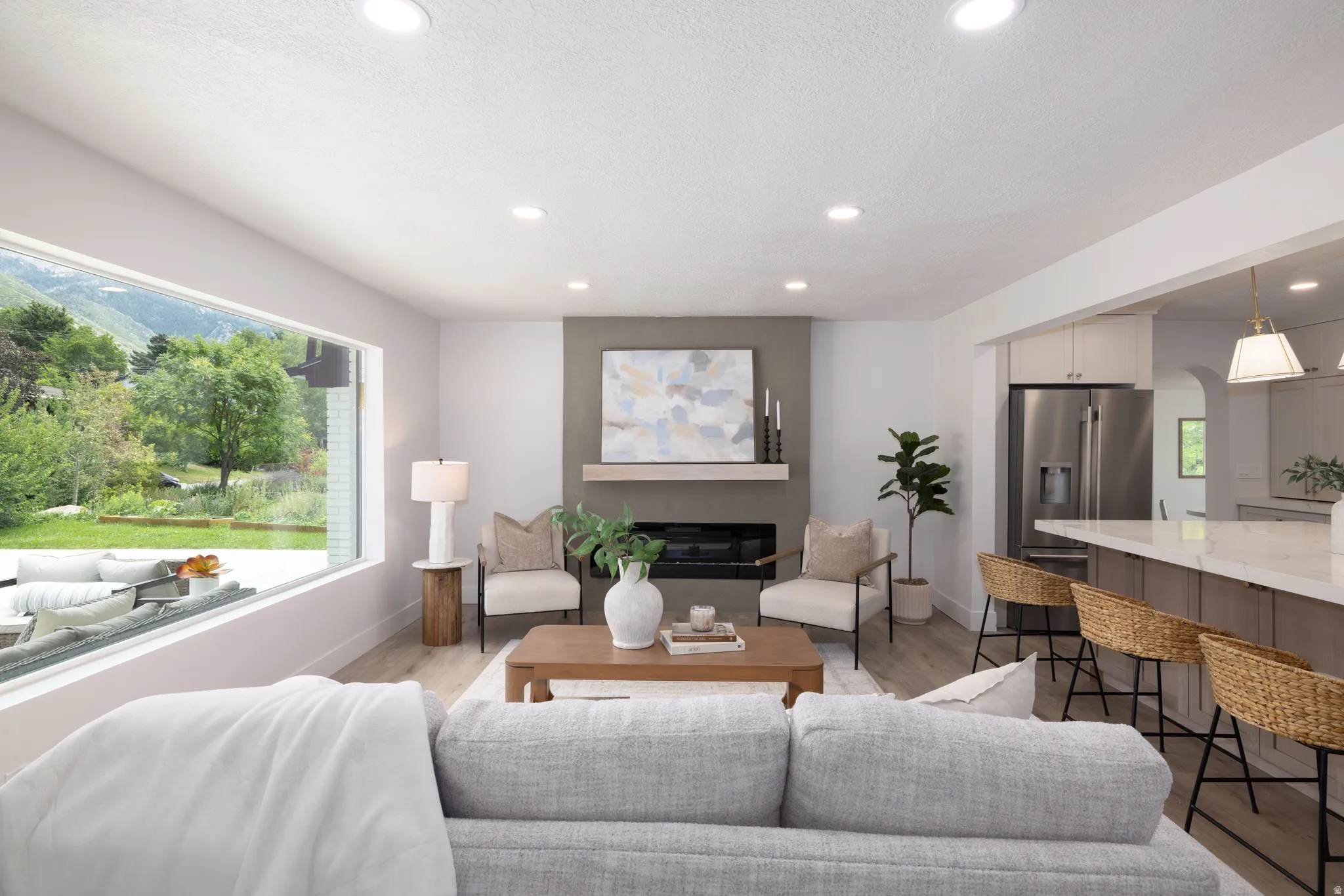Living area featuring a floor-to-ceiling window, a contemporary fireplace with a stone-finish surround, a wood mantel, and recessed lighting