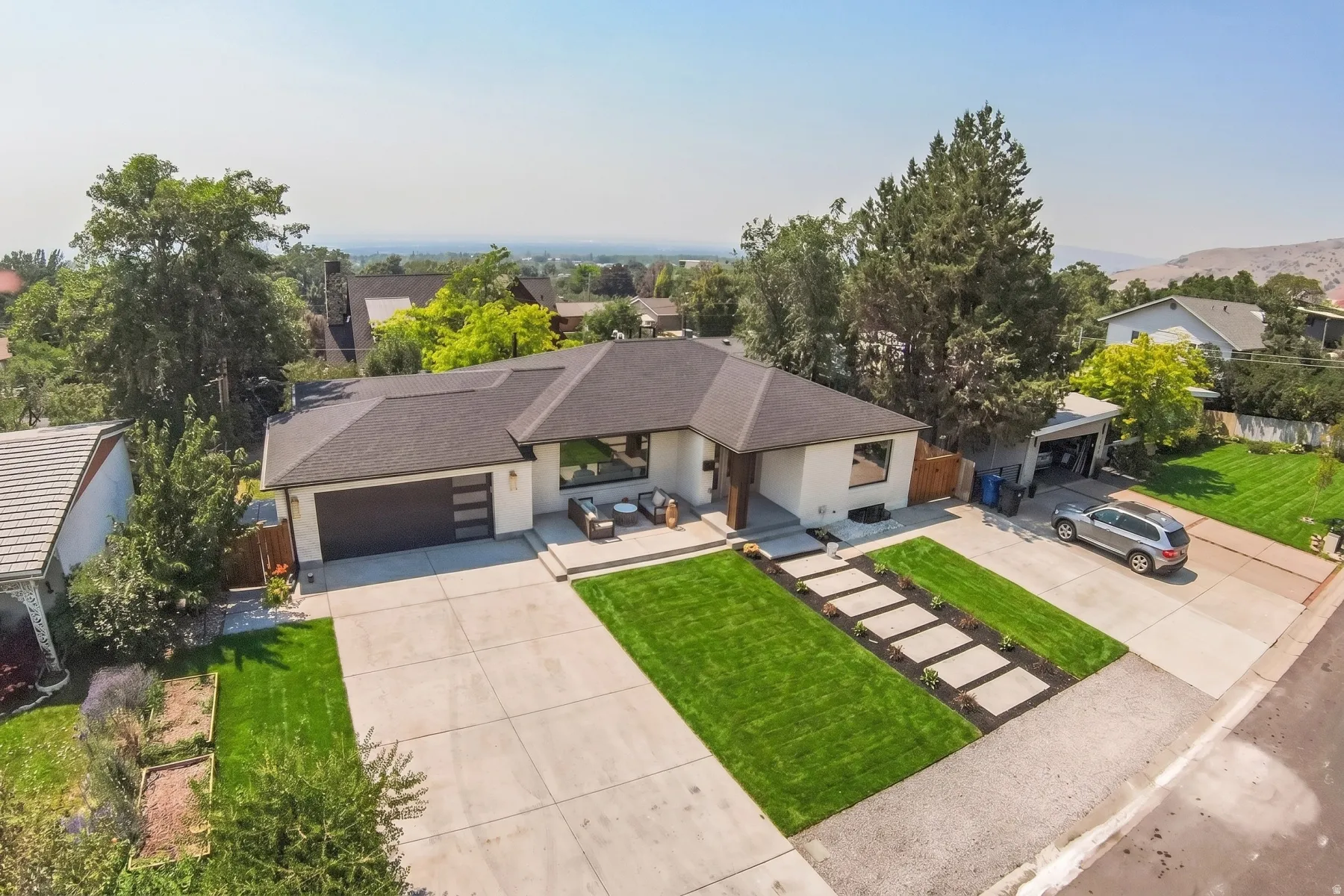 Contemporary single-story residence featuring a dark shingle roof and a two-car garage with a modern sectional door